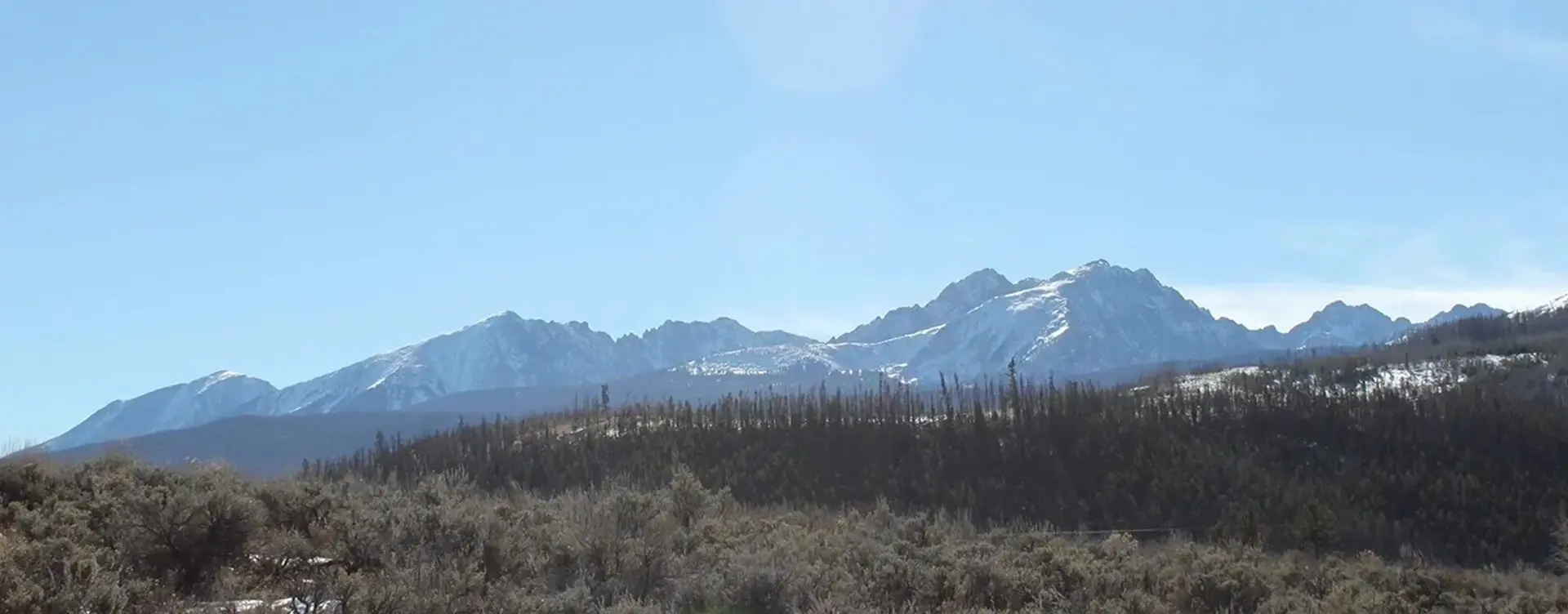 A view of mountains from the side of a road.