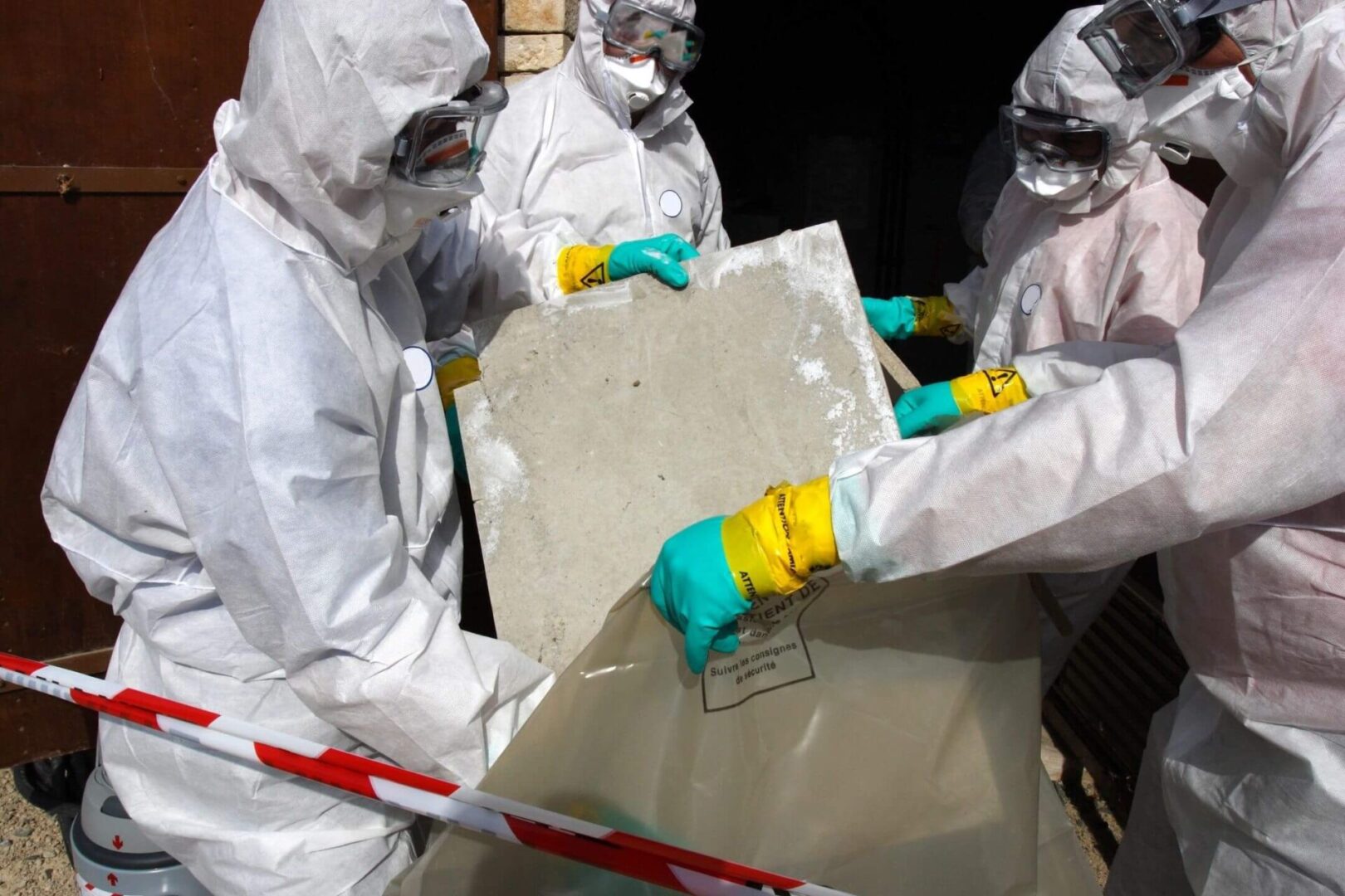 A group of people in hazmat suits holding a piece of paper.