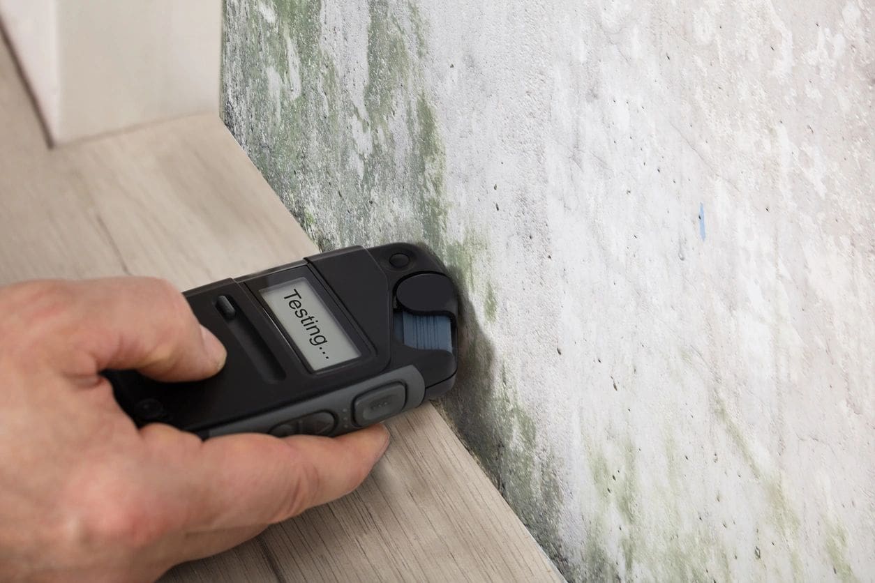 A person using a cordless phone to paint the wall.